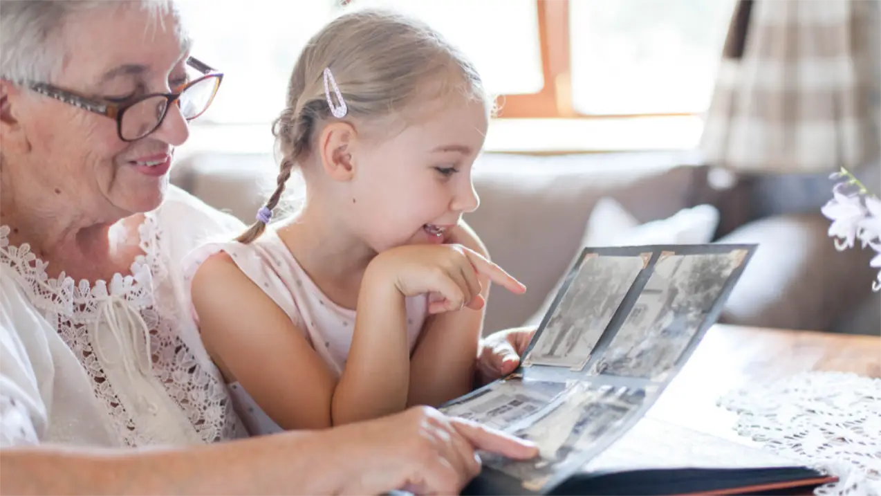 Oma und Enkelin schauen sich gemeinsam alte Fotos an