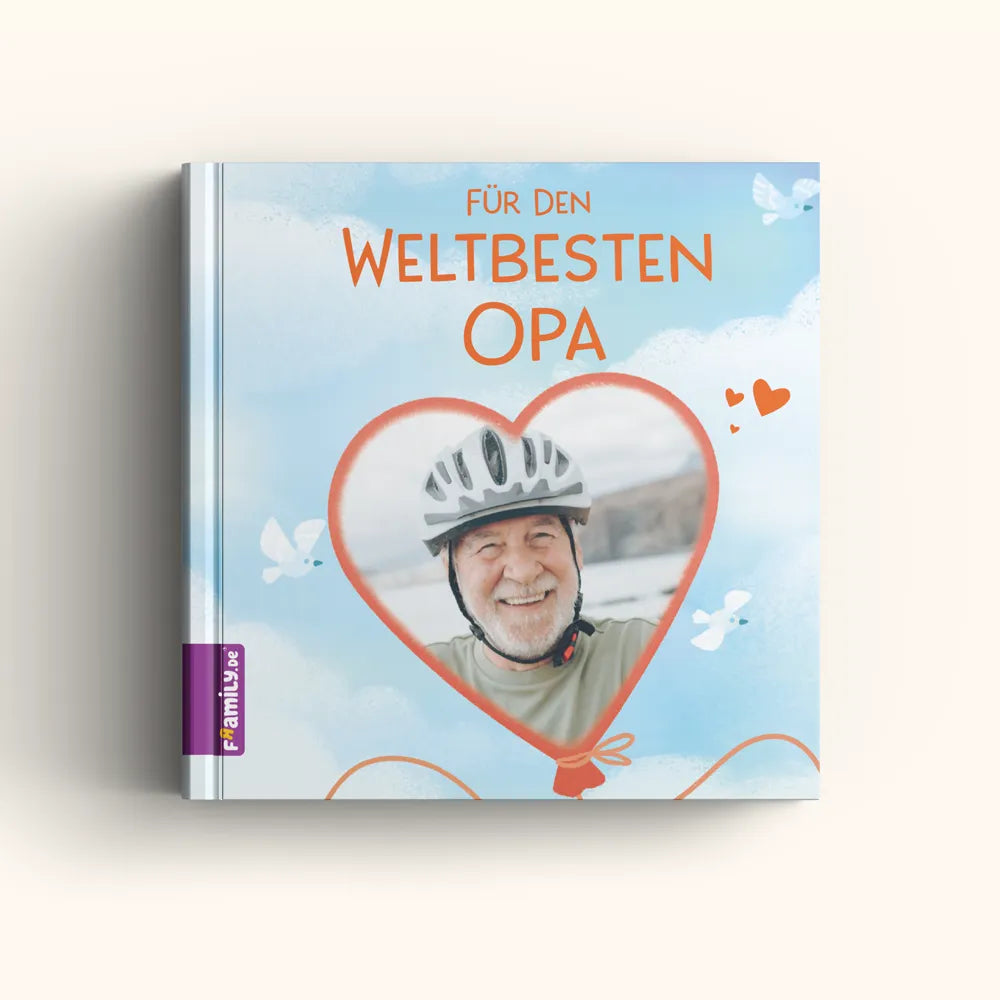 Das "Für den weltbesten Opa" Fotobuch-Cover von Framily zeigt das Foto eines lächelnden Seniors mit Fahrradhelm im Herzrahmen, vor himmelblauem Hintergrund mit weißen Tauben - das perfekte Geschenk für Opa.