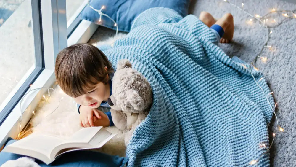 Junge liest Teddybär vor