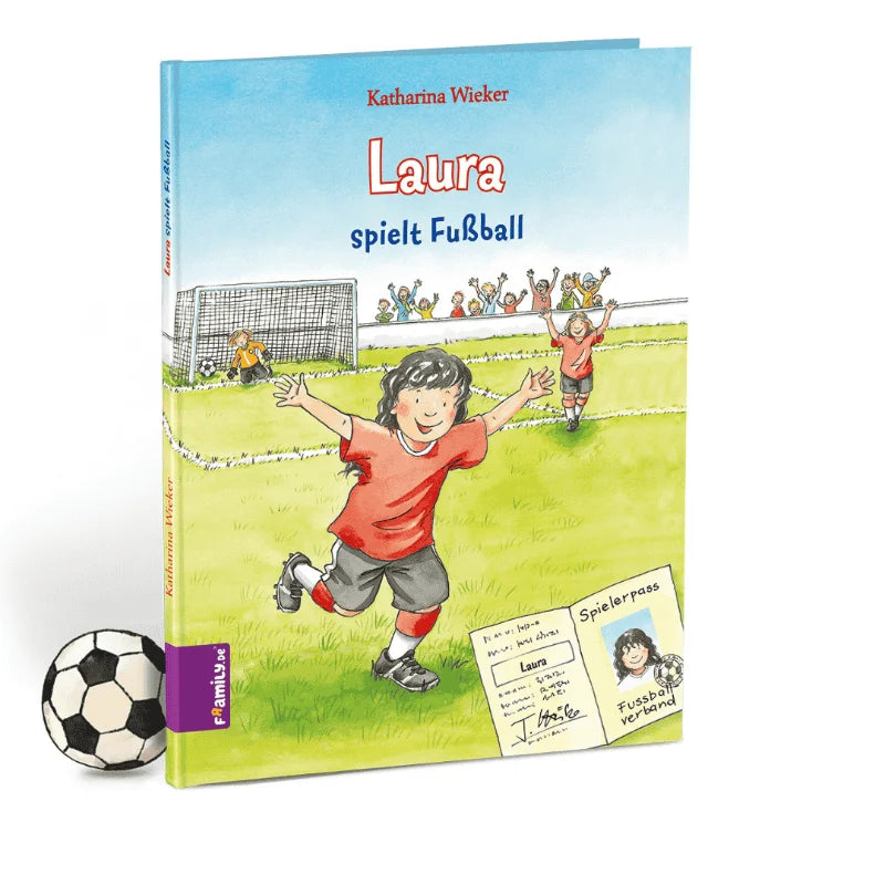 Das Kinderbuch Deine erste Fußballgeschichte von Framily zeigt ein Mädchen in einem roten Fußballtrikot, das auf dem Spielfeld mit Mannschaftskameraden und einem Tor eine inspirierende Fußballgeschichte erzählt; ein kleiner Fußball liegt neben dem Buch.
