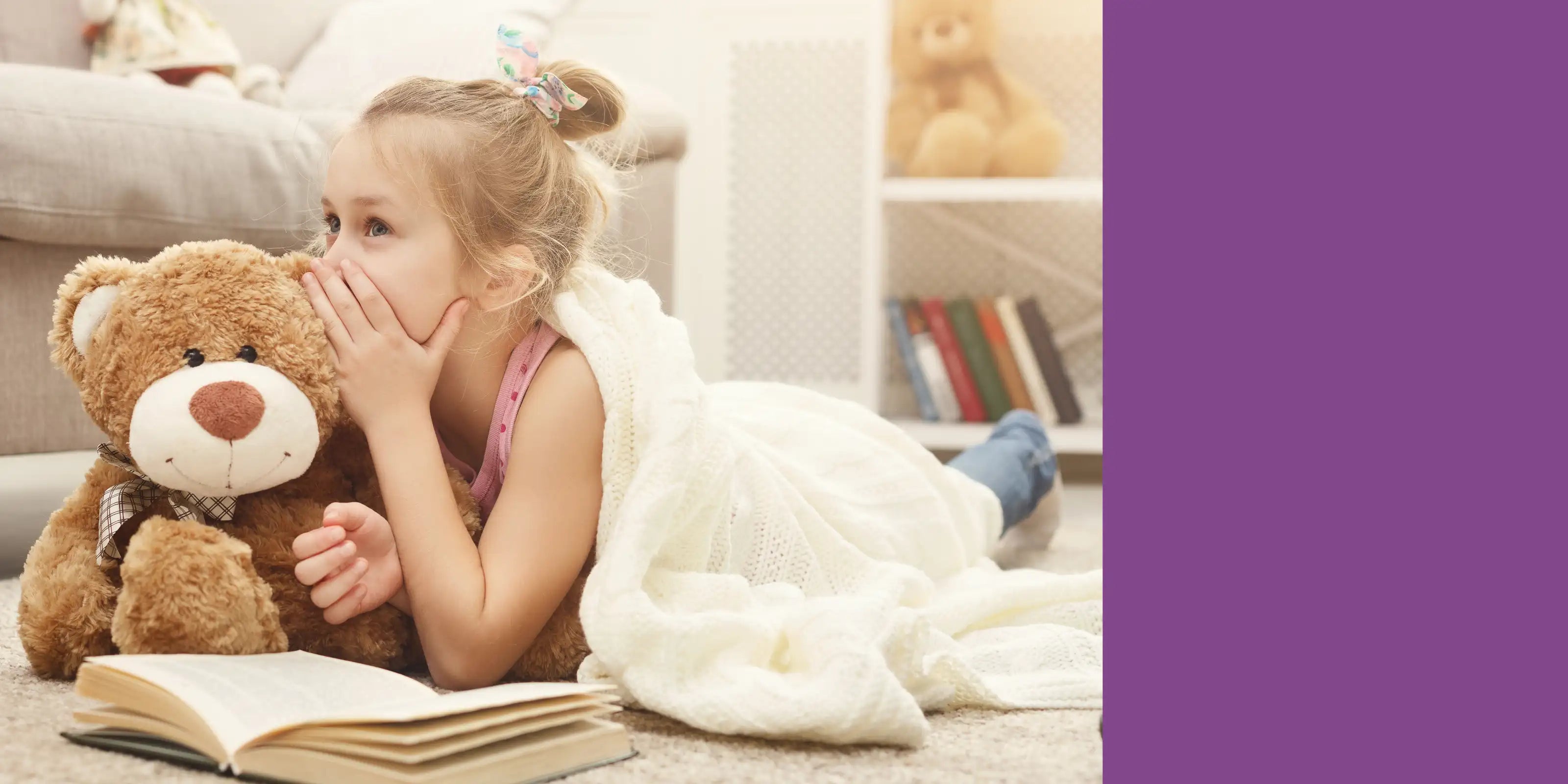 Mädchen flüstert Teddybär ins Ohr