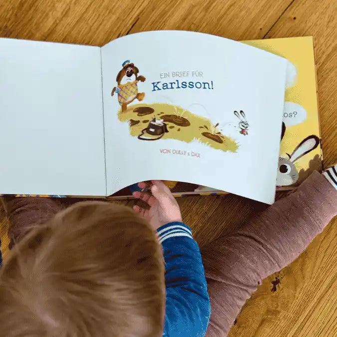 Ein kleiner Junge blättert in seinem personalisiertem Briefbuch