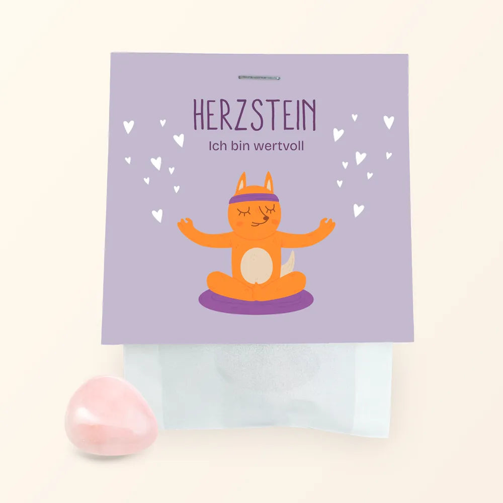 Der Herzstein von Framily ist ein Rosenquarz, der in einer Tüte mit einem süßen meditierenden Fuchs unter den Worten "Ich bin wertvoll" als Etikett verpackt ist.