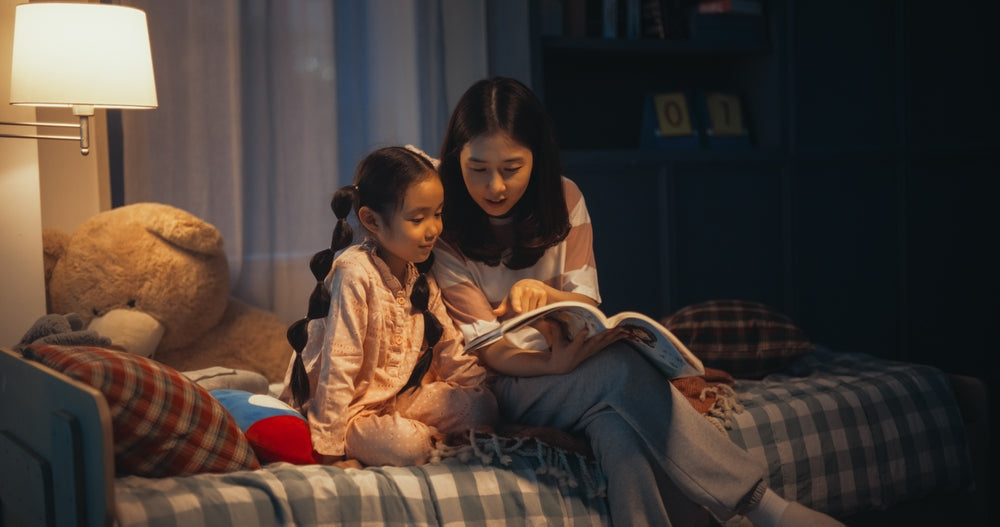 Eine Mutter liest ihrer Tochter ein Buch vor dem Einschlafen vor
